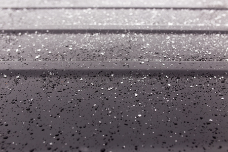 Snowflakes on a black car as a background .の写真素材