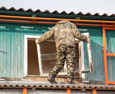 Workers remove the old window in the house .の写真素材