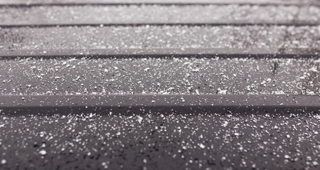 Snowflakes on a black car as a background .