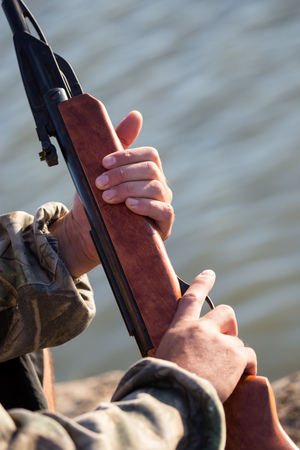 The gun in the hands of the hunter .