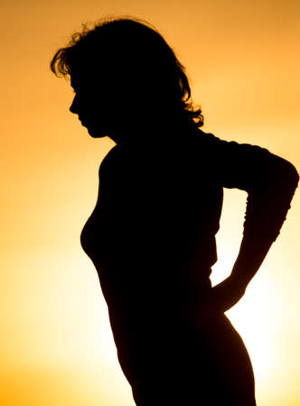 Silhouette of a girl in the sunset .の写真素材