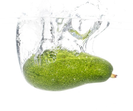 Avocado under water on a white background .の写真素材