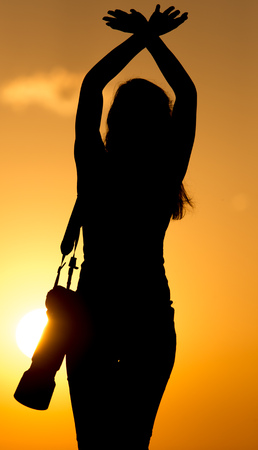 Silhouette of a girl photographer at sunset .の写真素材