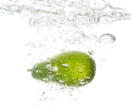 Avocado under water on a white background .の写真素材