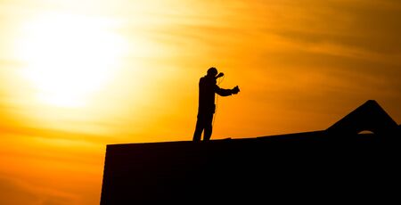 Man at the house under construction at sunset .の写真素材