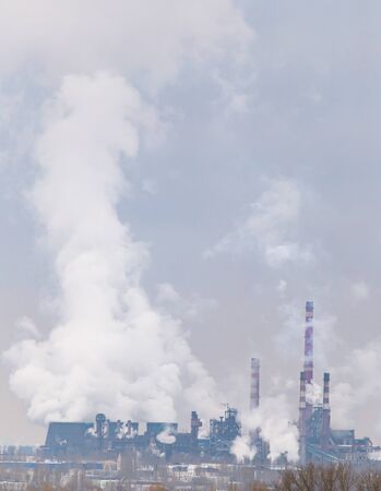 Smoke from the pipes in the factory in the morningの写真素材