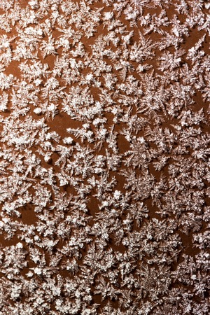 A snowflake on a brown fence as a background. Macro