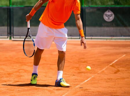 A man is playing tennis on the court .