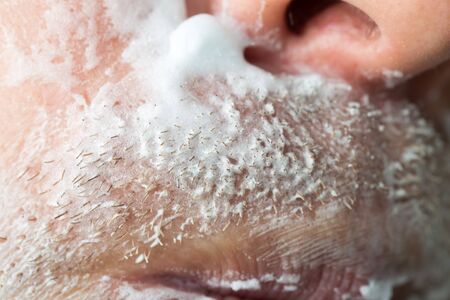 A man is applying face shaving foam .の写真素材