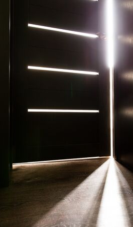 Rays of light from the door in a dark room .の写真素材
