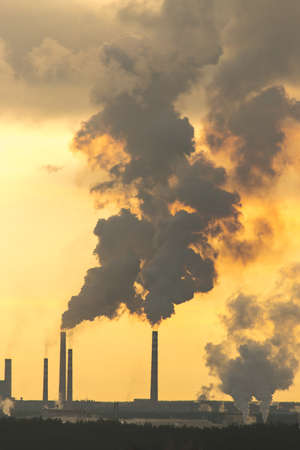Smoke from the pipes in the factory in the morningの写真素材