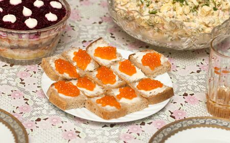 Dishes from sliced bread and red caviar .