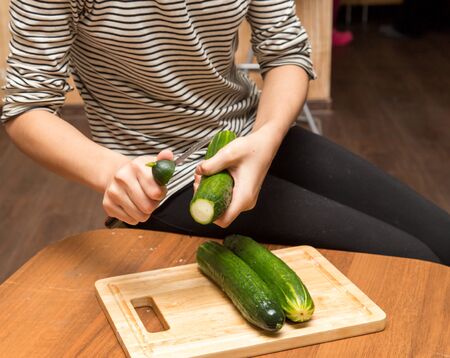 Slicing cucumber with a knife on the board .の写真素材