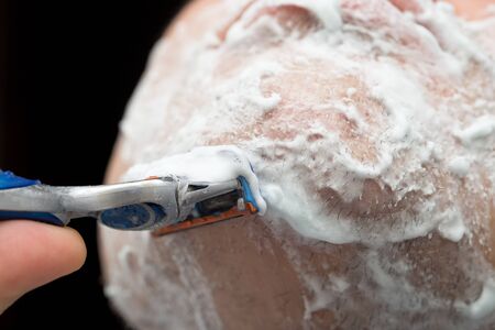 The man is shaving with foam machine .