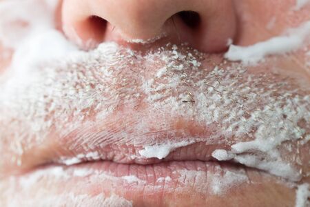 A man is applying face shaving foam .の写真素材