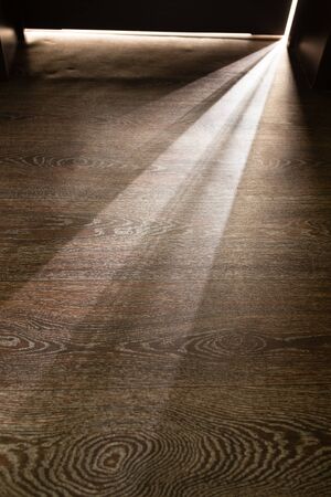 Rays of light from the door in a dark room .の写真素材