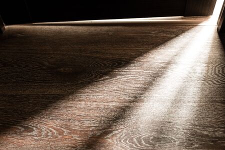 Rays of light from the door in a dark room .の写真素材
