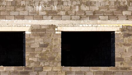 Windows in a brick house under construction as a backgroundの写真素材