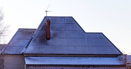 Snow on the roof of the house in winter .の写真素材