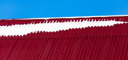 Snow on the roof of the house in winter .の写真素材
