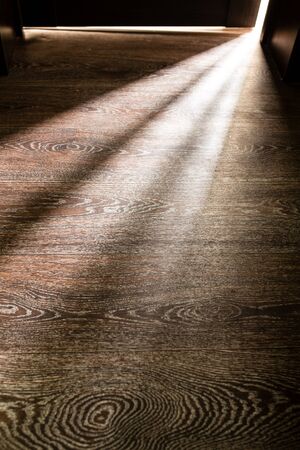 Rays of light from the door in a dark room .の写真素材