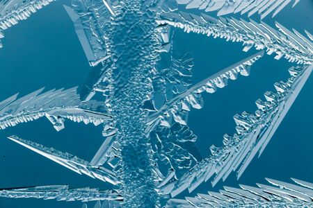 Blue drawings on the glass in the frost .