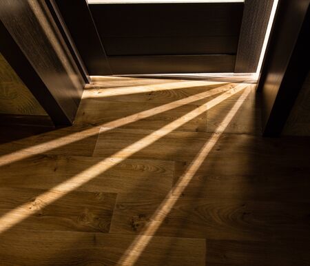 Rays of light from the door in a dark room .の写真素材