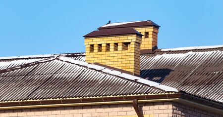 Snow on the roof of the house in winter .の写真素材