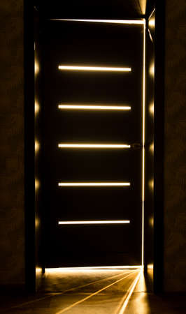 Rays of light from the door in a dark roomの写真素材