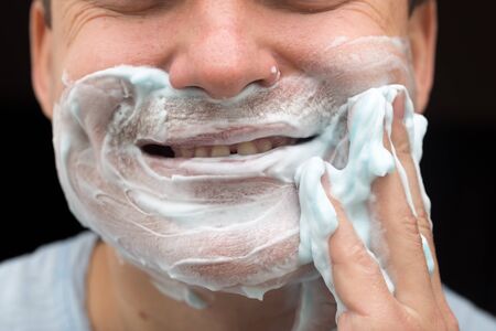 A man is applying face shaving foamの写真素材