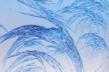 Blue drawings on the glass in the frost .