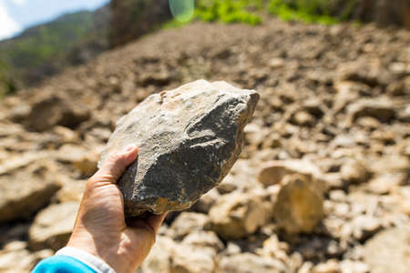 Stone in hand in nature in the mountainsの写真素材