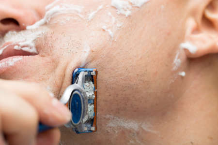 The man is shaving with foam machineの写真素材
