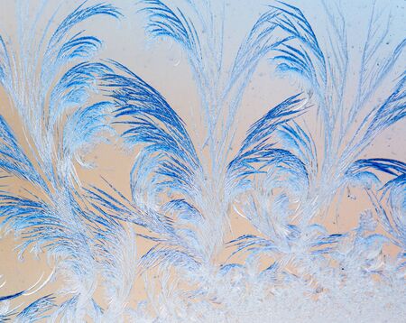 Blue drawings on the glass in the frost .
