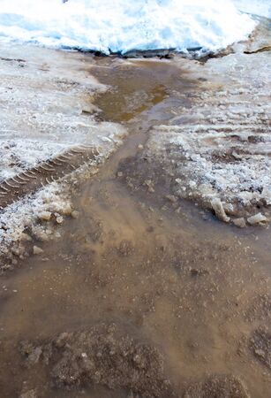 Snow melts on the road as a background .の写真素材