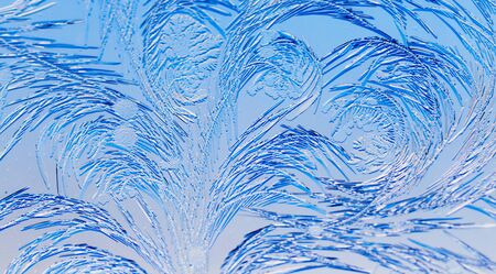 Blue drawings on the glass in the frost .