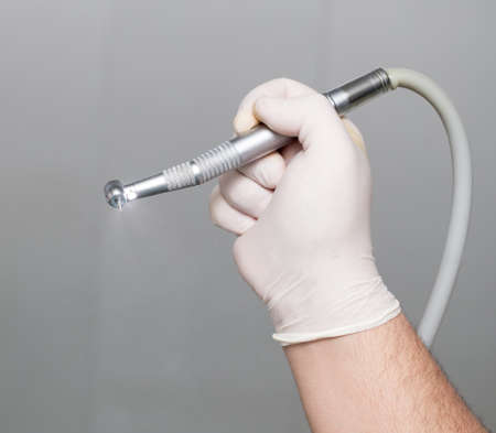 The dentist holds a tool in his hand .の写真素材