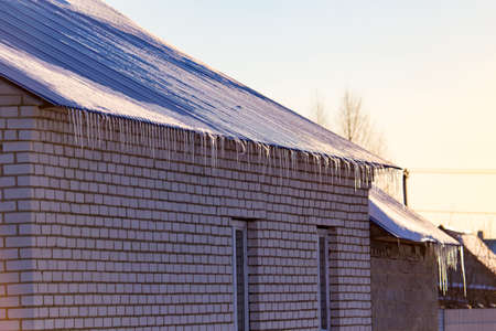 The roof of the house in the rays of the sunset in winter .の写真素材