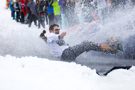 LIPETSK, RUSSIA - MARCH 31, 2018: A man snowboarding from mountain to waterのeditorial素材