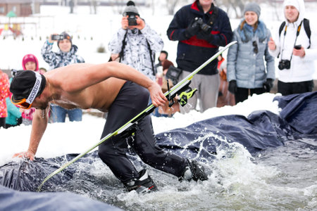 LIPETSK, RUSSIA - MARCH 31, 2018: A naked man skiing from the mountain to the waterのeditorial素材