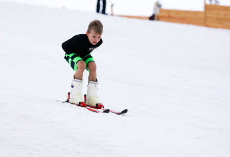 LIPETSK, RUSSIA - MARCH 31, 2018: A kid skiing from the mountain to the waterのeditorial素材