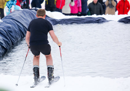 LIPETSK, RUSSIA - MARCH 31, 2018: A naked man skiing from the mountain to the waterのeditorial素材