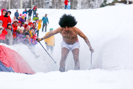 LIPETSK, RUSSIA - MARCH 31, 2018: A naked man skiing from the mountain to the water