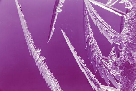 Purple patterns on the glass in the frost .