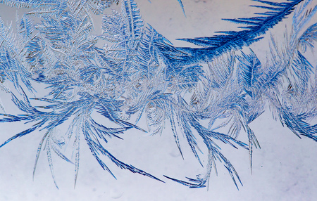 Figures on the glass from the frost at sunrise as a background .
