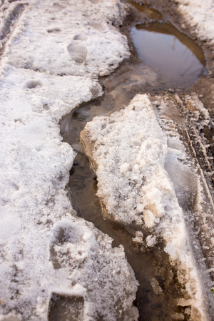 Snow melts on the road as a background .の写真素材