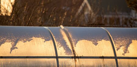 Greenhouse in the rays of sunset in nature .