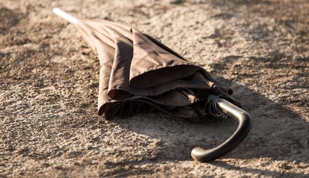 The umbrella lies on the ground at sunset