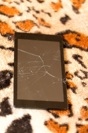 Tablet with a broken screen on the background of tiger skinの写真素材