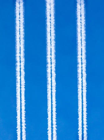 Traces of white smoke from an airplane on a blue sky .の写真素材